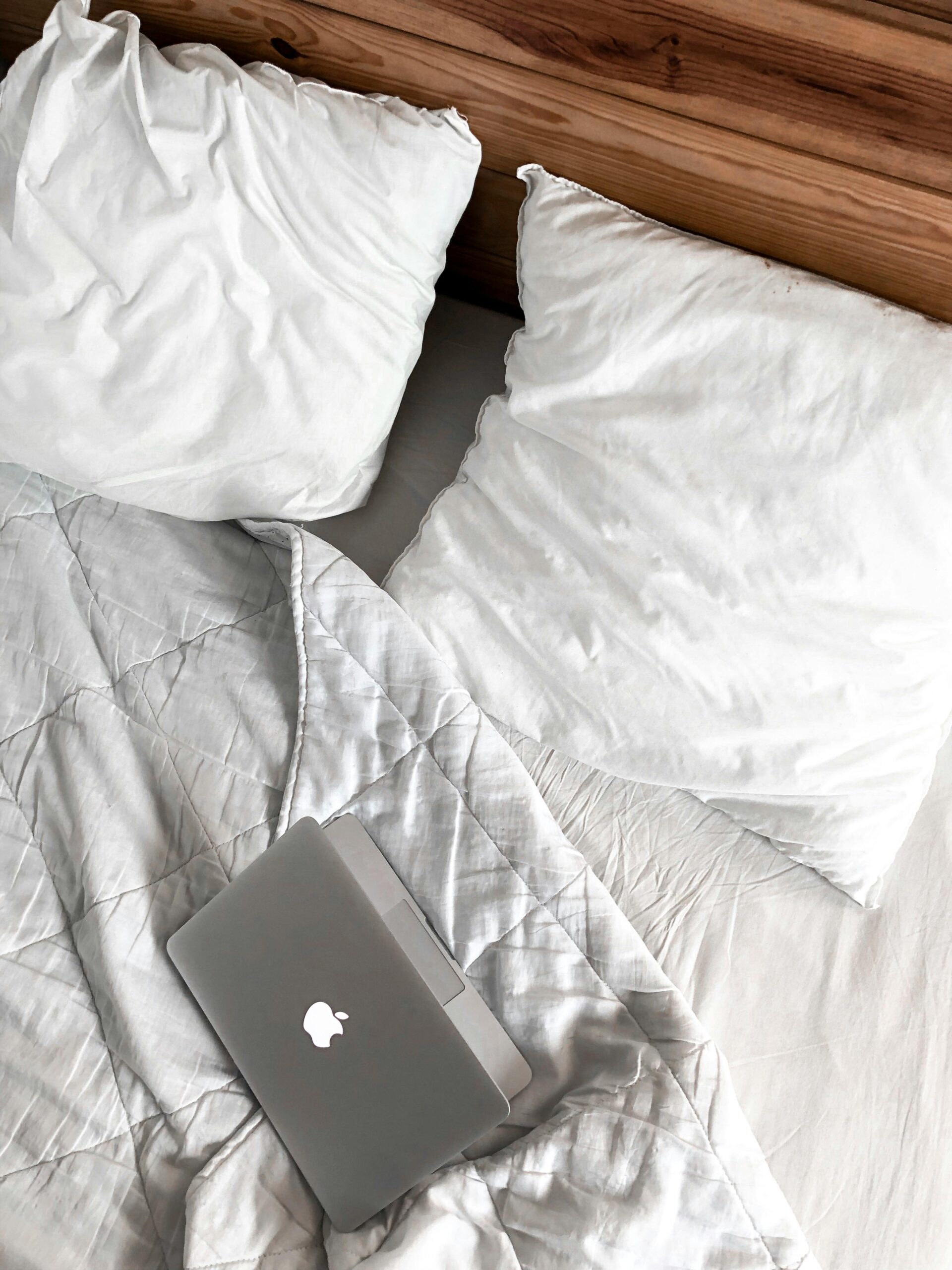 A comfortable bedroom scene with a laptop on a bed, perfect for remote work or relaxation.